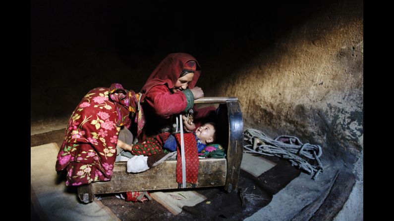 A mother tends to her son inside their home in Afghanistan's <a href="index.php?page=&url=http%3A%2F%2Fcnnphotos.blogs.cnn.com%2F2014%2F06%2F22%2Fon-top-of-the-world-untouched-by-war%2F" target="_blank">Wakhan Corridor</a> in October 2007.