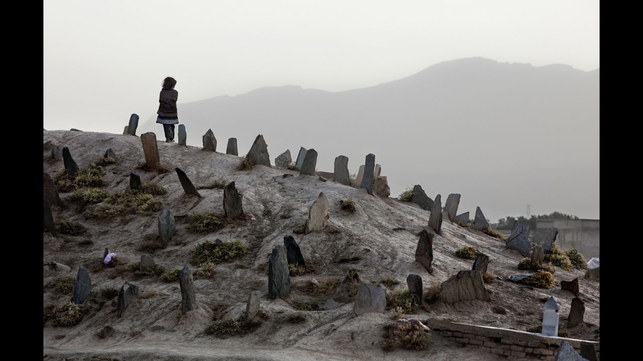 A girl stands on a cemetery hill after attending a funeral in Kabul in October 2009.