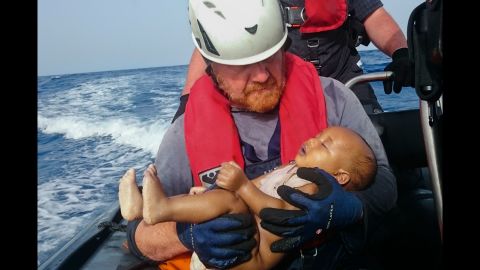 A member of the humanitarian organization Sea-Watch holds a migrant baby who drowned following the capsizing of a boat off Libya in May 2016.