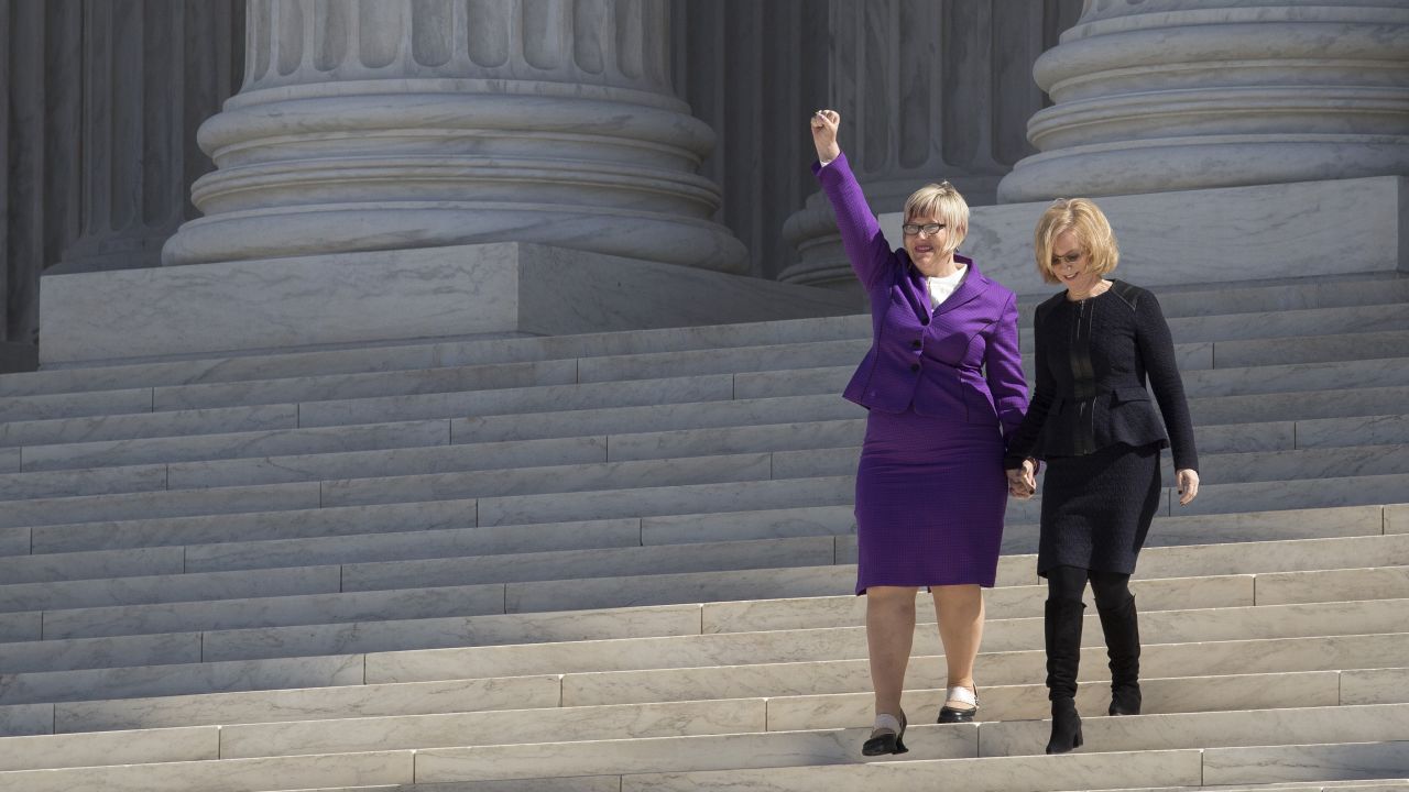 Amy Hagstrom Miller, founder and CEO of Whole Woman's Health, gestures to the crowd as she and Nancy Northup, president of the Center for Reproductive Rights, walk down the steps at the Supreme Court in Washington, DC, on March 2, 2016.  