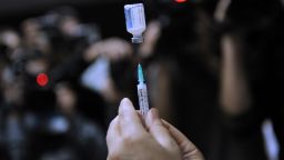 A nurse prepares a shot of the A(H1N1) vaccine (Pandemrix from Glaxo Smith Kline -GSK- laboratory) to a hospital staff member in Istanbul, on November 2, 2009. Turkey began vaccinating medical workers Monday as the death toll from the A(H1N1) virus in the country reached six, the health ministry said.   The latest victims of the disease were a 22-month-old baby and a 14-year-old boy who died overnight in the central city of Konya, a ministry statement said. Nine other people infected with swine flu were in serious condition in intensive care at the country's medical facilities, it added. AFP PHOTO / BULENT KILIC (Photo credit should read BULENT KILIC/AFP/Getty Images)