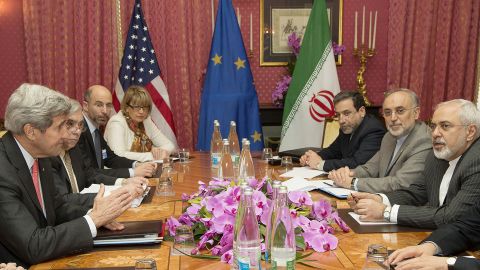 US Secretary of State John Kerry (L) expresses his condolences over the death the of the mother of Iranian President Hassan Rouhani (unseen) before a negotiation session with Iran's Foreign Minister Javad Zarif (R) over Iran's nuclear program in Lausanne March 20, 2015, as European Union Political Director Helga Schmid (4-L) looks on.