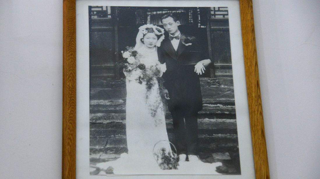Liu's inlaws lived inside this building before they passed away. The couple came from wealthy families and were persecuted during the Cultural Revolution. This wedding photo, taken in the early 1940s and hanging on the wall of their room, is the only one that survived the Cultural Revolution, when a Western-style wedding photo would be destroyed because it was "bourgeois." 