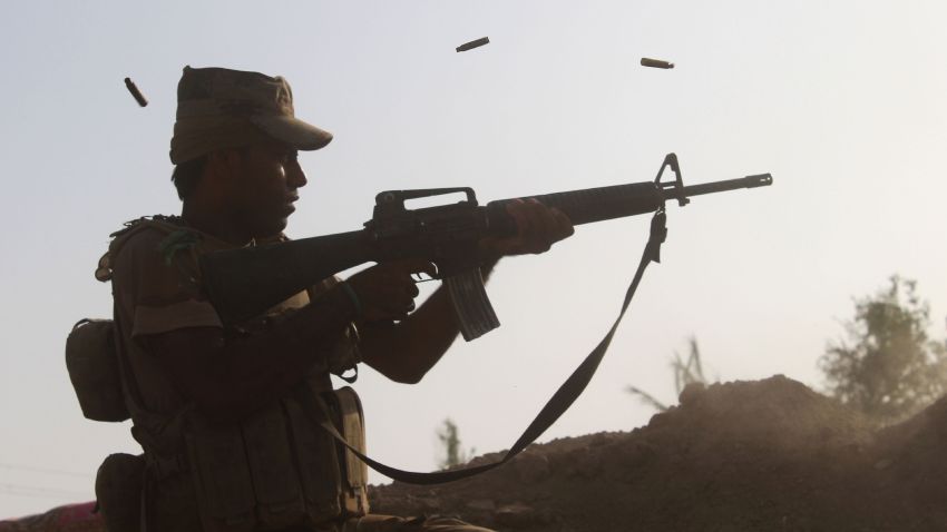 A member of the Iraqi pro-government forces fires his weapon on a front line in the Albu Huwa area south of Falluja on June 1.