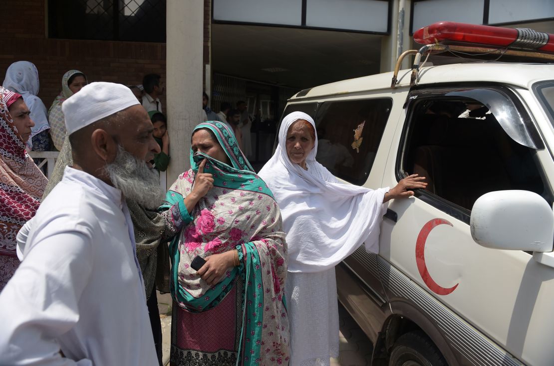 Pakistani relatives stand alongside an ambulance carrying Maria Abbasi, June 1, 2016.