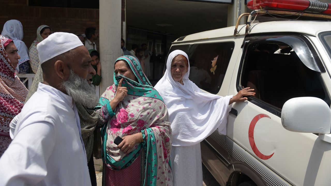 Pakistani relatives stand alongside an ambulance carrying Maria Abbasi, June 1, 2016.