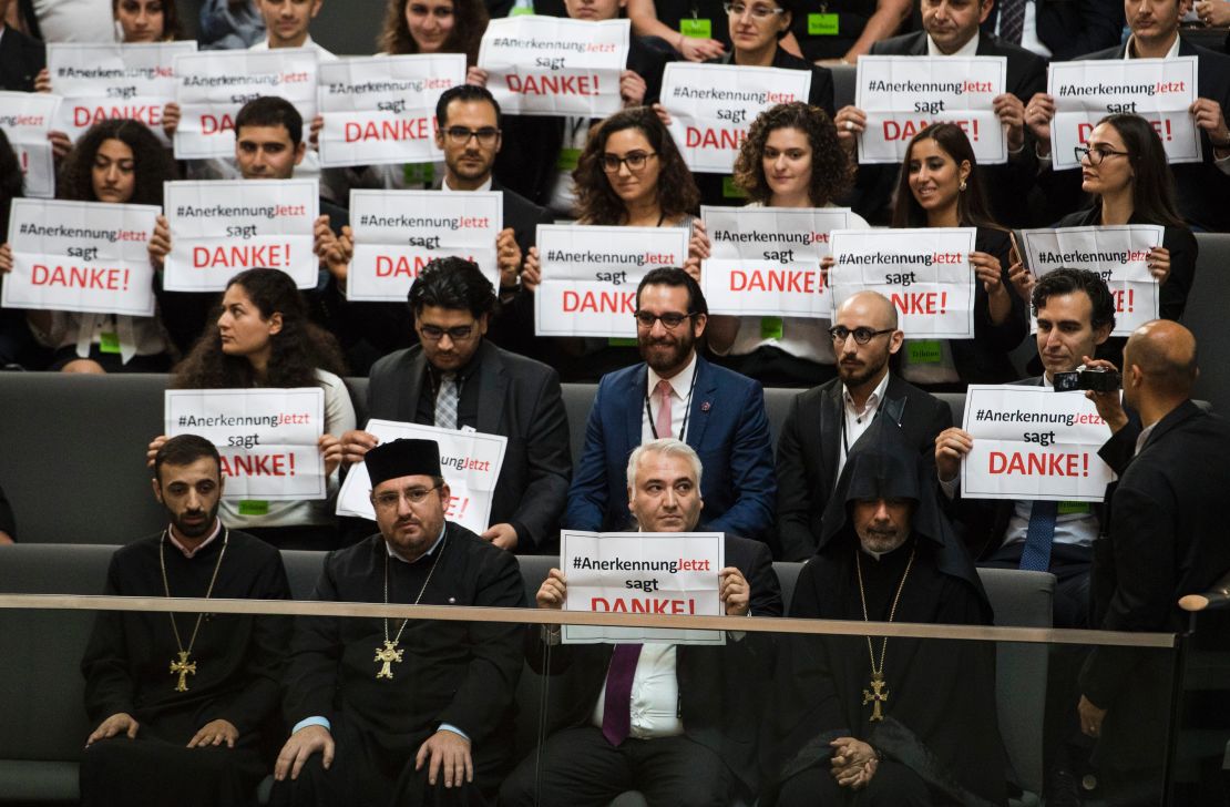 Armenian clergy men and activists hold up signs saying "thank-you" after the vote.  