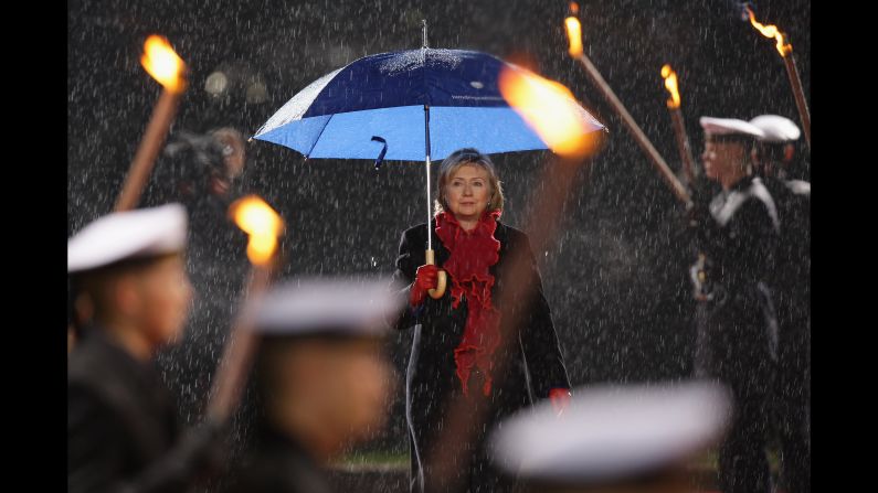 Clinton reviews an honor guard carrying torches at Bellevue Castle on November 9, 2009, in Berlin. 