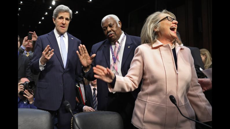 Sen. John Kerry talks with committee staffer Bertie Bowman as U.S. Secretary of State Hillary Clinton attends Kerry's Senate confirmation hearing after Kerry was nominated to succeed her as secretary of state.