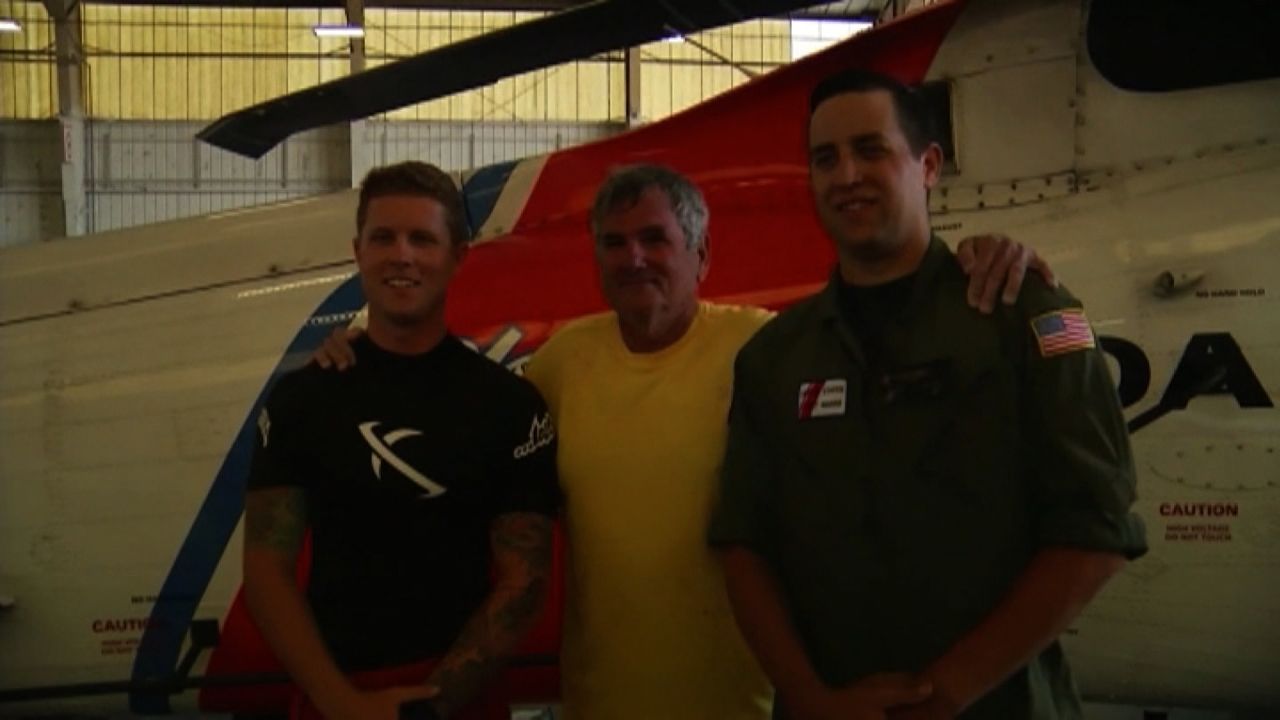 William Durden, center, with Coast Guard rescuers after being pulled from Gulf of Mexico