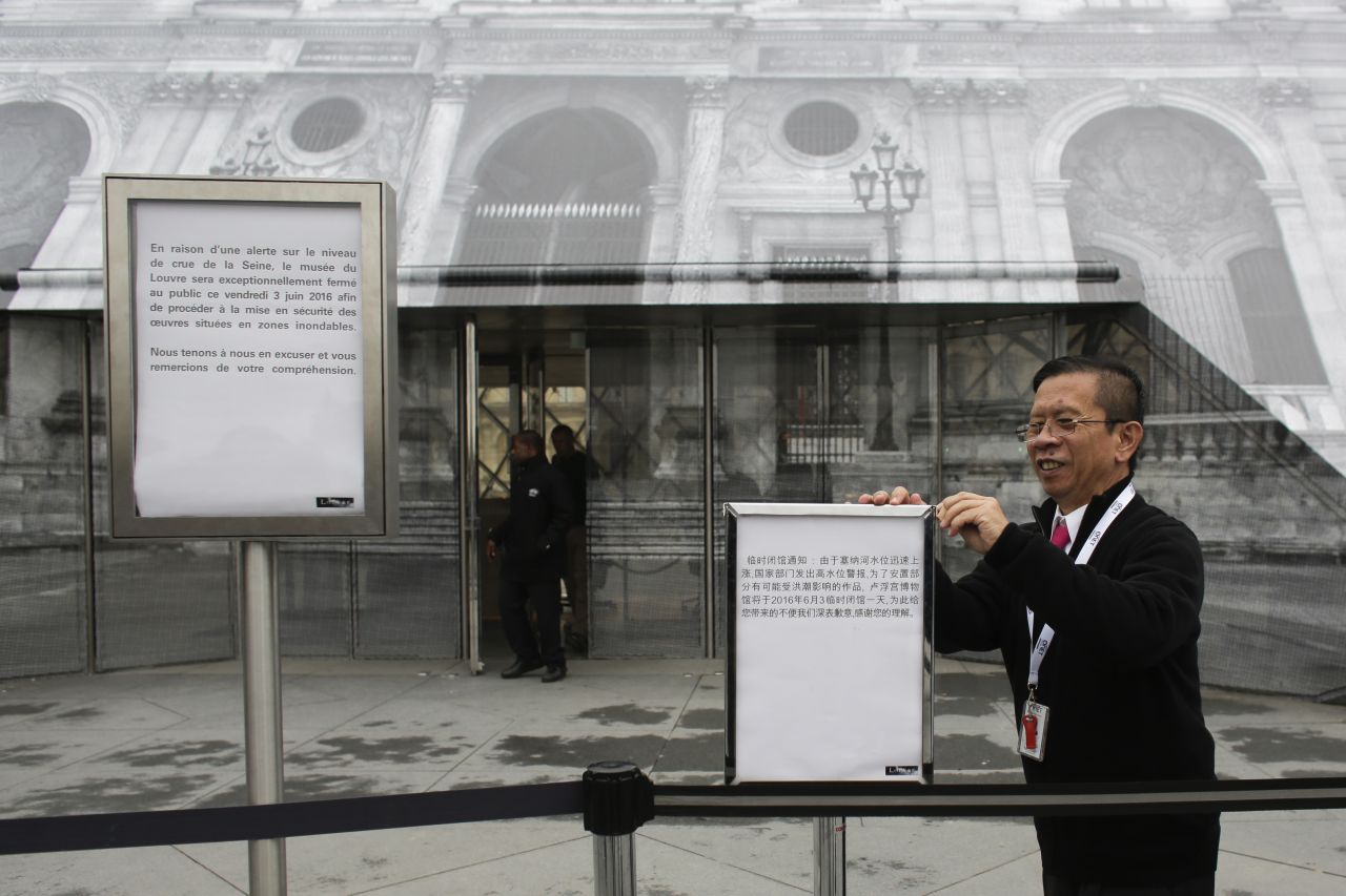 Staff of the Louvre post signs on June 3, informing visitors about the closing of the famous museum due to flooding in the city. 