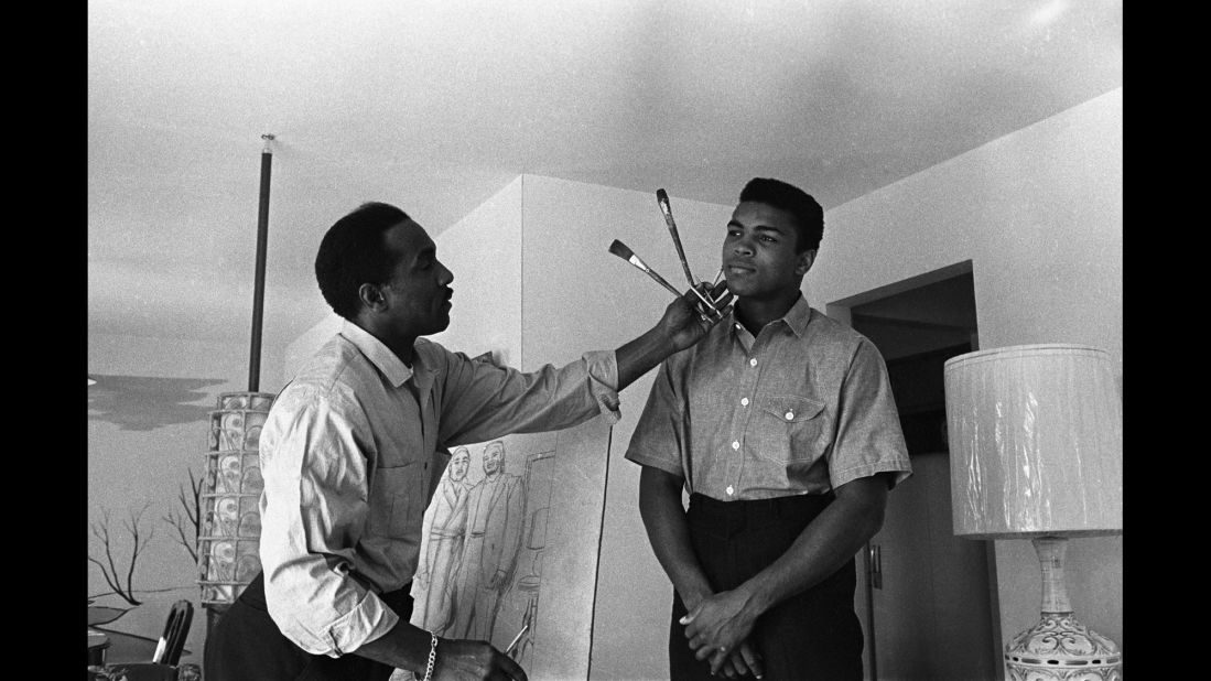 Ali poses in 1963 while his father works on a portrait.