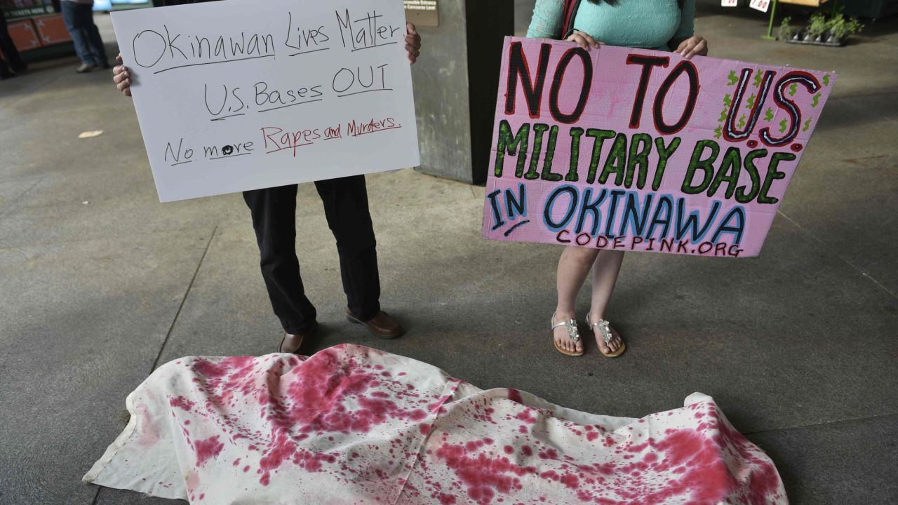 Activists, including some who are covered in mock shrounds, take part in a demonstration to protest against the US military presence in Okinawa, Japan, outside of Union Station in Washington, DC on May 26, 2016.