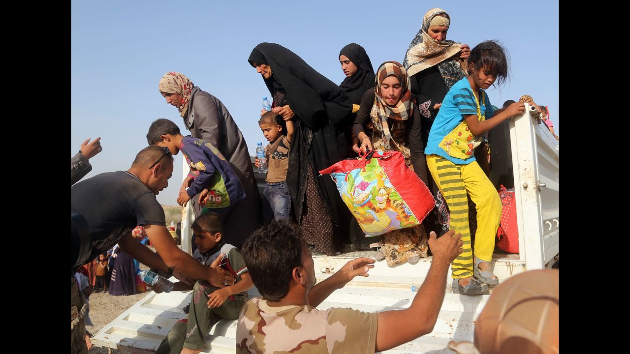 Iraqi soldiers help civilians from a vehicle outside a camp near Falluja on Friday, June 3.