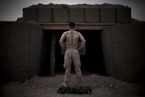 3rd Battalion, 6th Marines, Sgt. Paul Williams shows his tattoos at the entrance to a bunker at a base in Afghanistan on March 20, 2010.