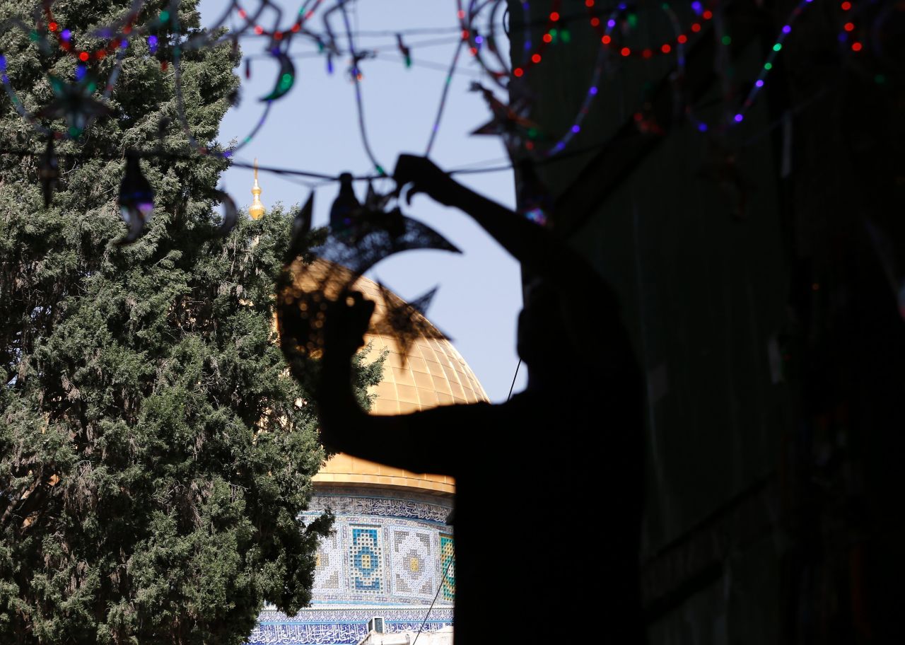 A Palestinian man decorates his shop with lights near the entrance of the al-Aqsa mosque in Jerusalem on June 5.