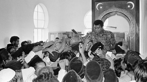Muslims reach out to shake hands with Muhammad Ali during his visit to a mosque in Kuala Lumpur, Malaysia, in June 1975. After leaving the Nation of Islam, Ali followed Sunni Islam.