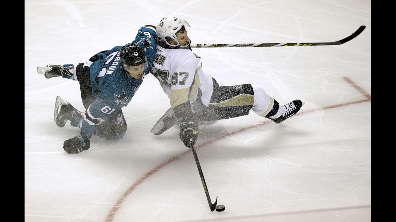 Pittsburgh center Sidney Crosby reaches for the puck in front of San Jose defenseman Justin Braun during Game 3 of the NHL's Stanley Cup Final on Saturday, June 4.