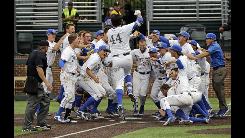 Austin Bush (No. 44) is welcomed at home plate by his UC Santa Barbara teammates after he hit a walkoff home run in the 14th inning to win an NCAA tournament game against Washington on Friday, June 3.