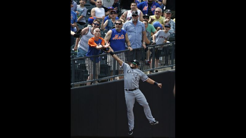 A baseball fan in New York reaches out for the same ball that Chicago White Sox outfielder Melky Cabrera was trying to catch on Wednesday, June 1. The play was ruled an out after video review.