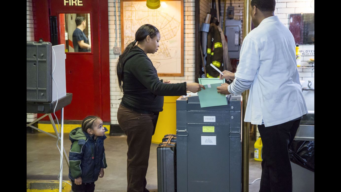 A boy watches his mother vote at a fire station in Detroit on Tuesday, March 8.