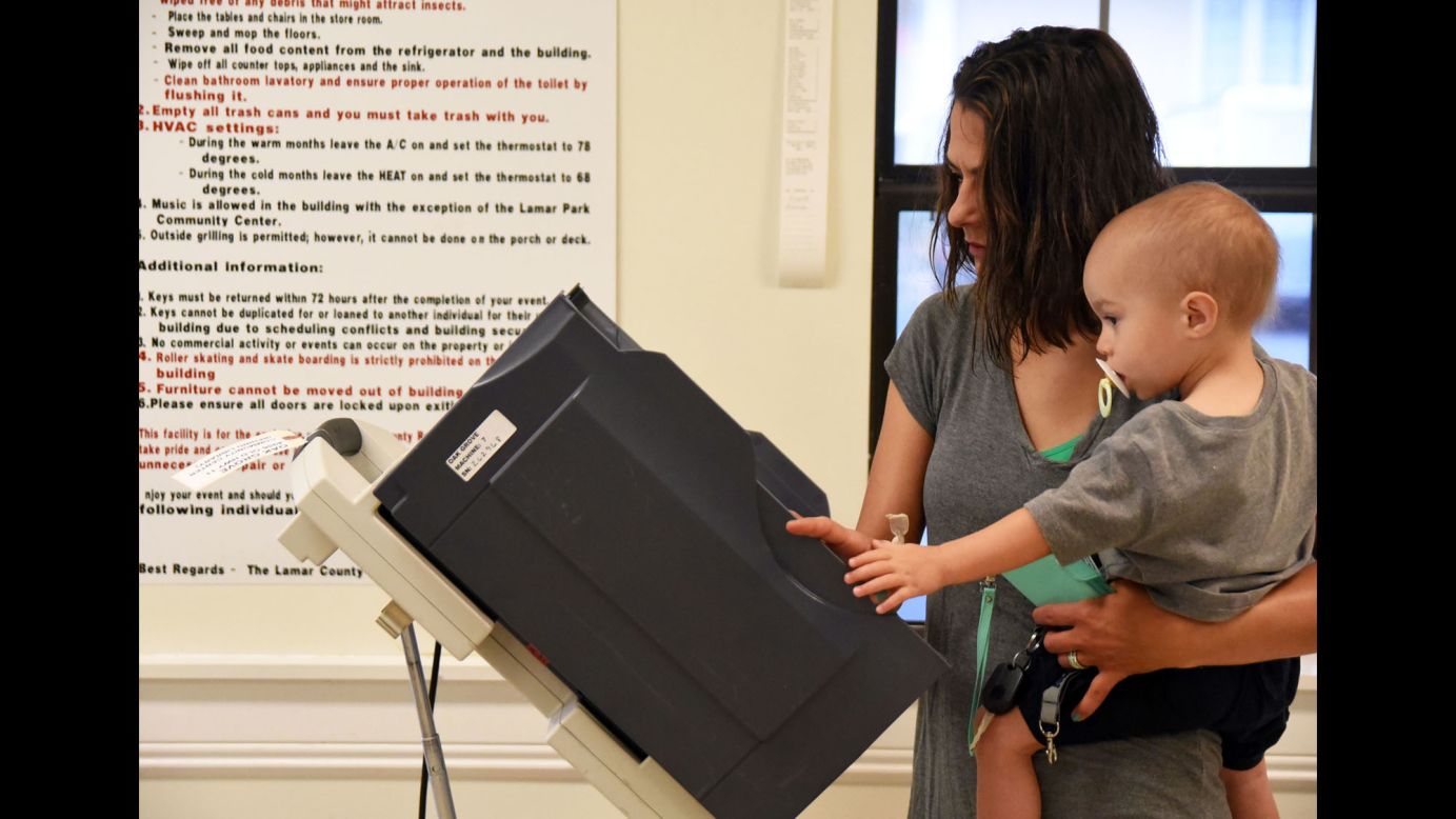 Kisha Raybor holds her 1-year-old son, Kullen, as she votes in Hattiesburg, Mississippi, on Tuesday, March 8.