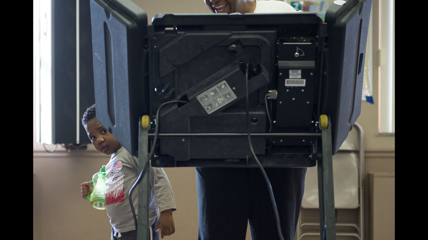 A child peeks around a voting booth in Ferguson, Missouri, on Tuesday, March 15.