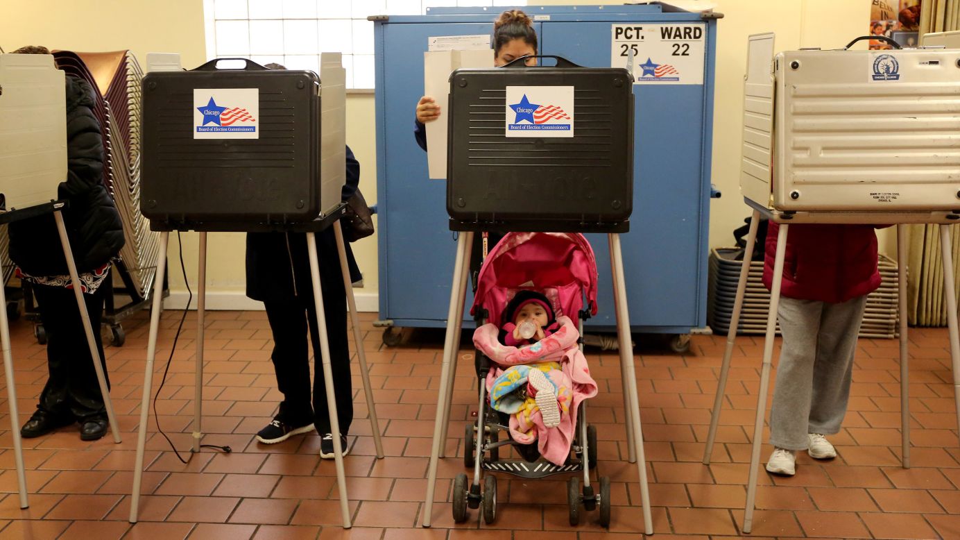 Adriana Reyes casts her vote as her 9-month-old daughter, Ariana, waits in Chicago on Tuesday, March 15.