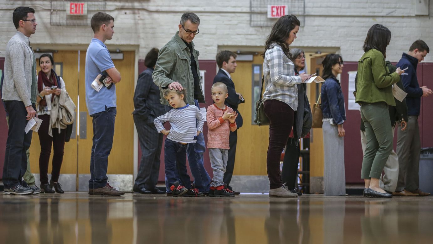 Steve Amos watches his sons, Cy, left, and Leon as he waits in line to vote Tuesday, March 1, in Atlanta.