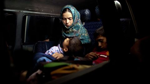 A boy sleeps in his mother's arms after fleeing from their home in Falluja on Monday, June 6.