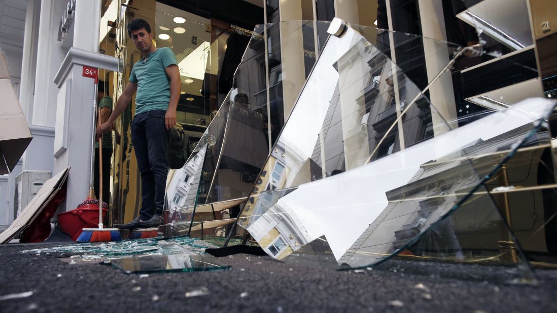 A man cleans debris outside his shop near the scene of the blast.