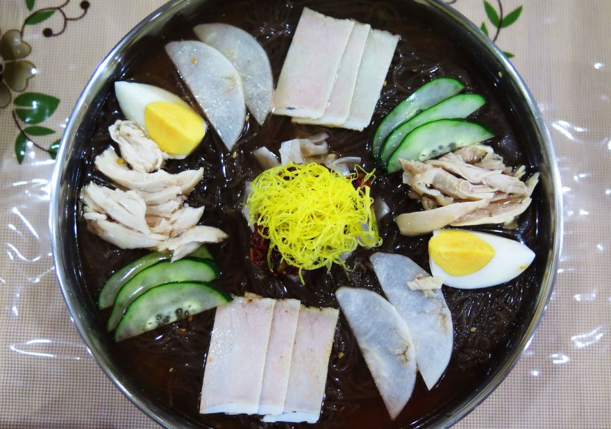 Large enough for two people,  Pyongyang Okryu's cold noodle tray includes slices of chicken, cucumber and a hard-boiled egg, plus red chilies, vinegar and mustard -- all draping spaghetti-like rice noodles, which a waitress will cut with big pink scissors.  