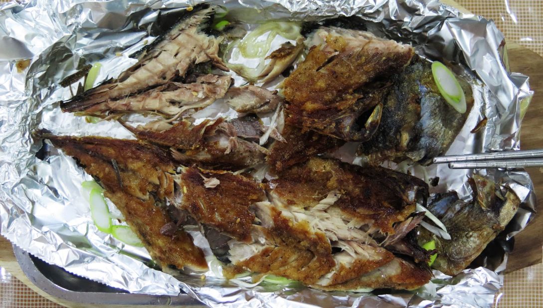 Pyongyang Okryu's fried mackerel and scallions, wrapped in aluminum foil, is graciously deboned by a waitress at your table.  