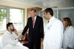 Turkish President Recep Tayyip Erdogan visits a man injured in the blast.