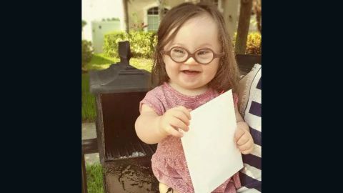 Emersyn Baker, 15 months old, holds a letter her mom wrote and sent to their doctor.