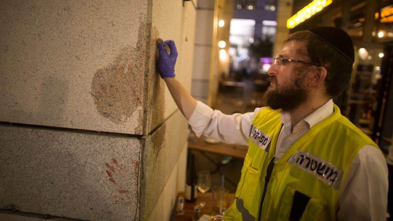 An investigator works the scene of the attack at Tel Aviv's Sarona Market.