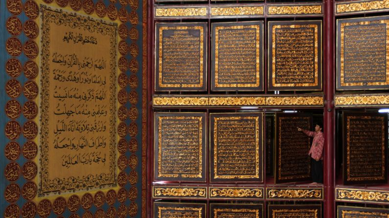 A man reads a large Quran made of carved wood at a school in Palembang, Indonesia, on Thursday, June 9. Ramadan, the most sacred month in the Muslim year, started on June 5.