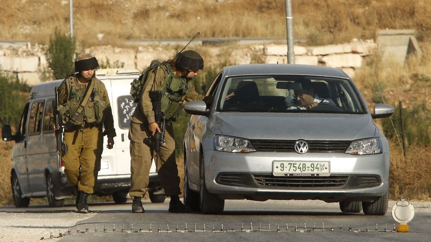 Israeli soldiers man a temporary checkpoint at the entrance of the Palestinian village of Yatta in the occupied West Bank on June 9,2016 after the army entered the village in search for clues leading to an attack the previous night in the Israeli city of Tel Aviv in which four people were killed and 16 others wounded. The two Palestinians assailants who carried out the attack came from Yatta, according to Israeli authorities. Israel said it had suspended entry permits for 83,000 Palestinians during the holy Muslim month of Ramadan following the shooting attack. / AFP / HAZEM BADER (Photo credit should read HAZEM BADER/AFP/Getty Images)