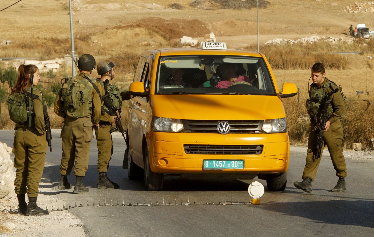 Israeli soldiers man a temporary checkpoint in the occupied West Bank on June 9, 2016. Israel said it had suspended entry permits for 83,000 Palestinians following a shooting in central Tel Aviv.