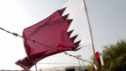 A Qatari flag flutters near a poster of Qatar's Emir Sheikh Hamad bin Khalifa al-Thani (L) at the construction site of a residential project funded by Qatar in Khan Yunis in the southern Gaza Strip on October 22, 2012.