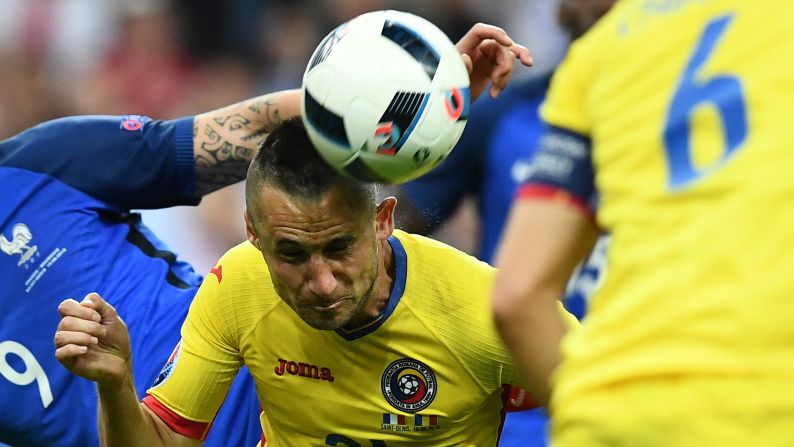 Romanian defender Dragos Grigore heads the ball during the match.