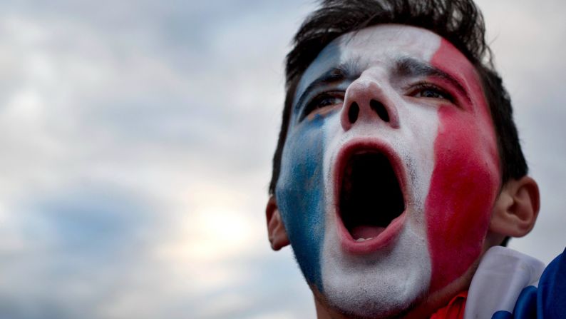 A France supporter, watching the match in Bordeaux, France, cheers during the national anthem.