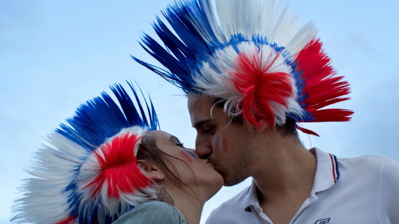 Two France supporters kiss in the Bordeaux fan zone before watching the match on television.