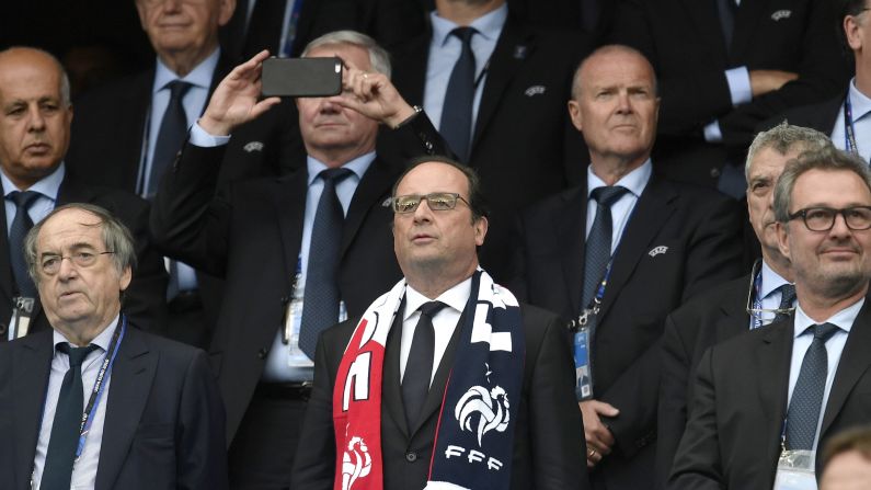 French President Francois Hollande wears a team scarf as he watches the opening ceremony from the stands.