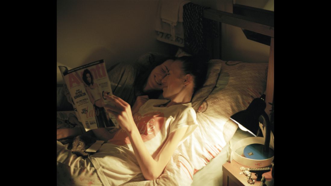Karolina and Kaia sneak into the same bed and read magazines together one night.