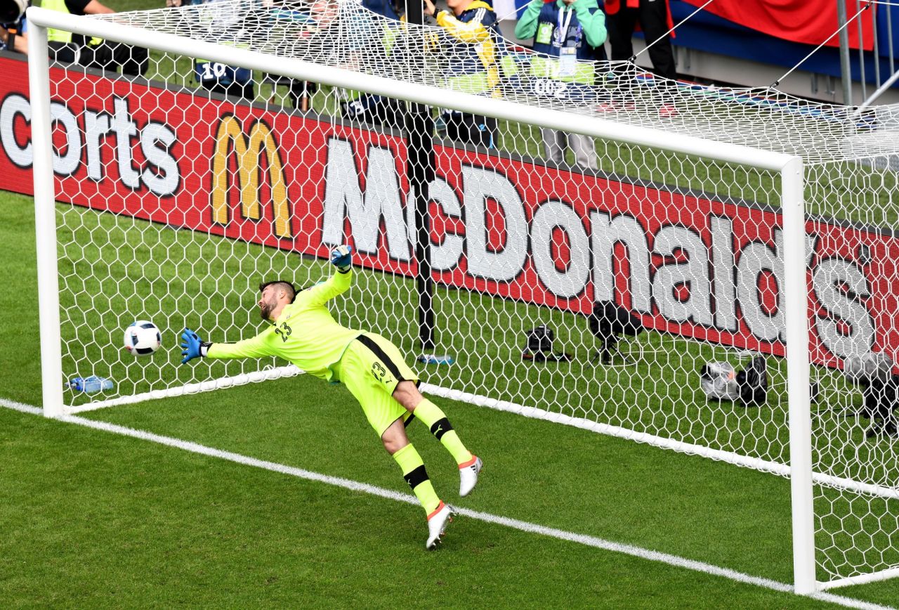 Matus Kozacik of Slovakia dives in vain as Gareth Bale scores a free kick goal.