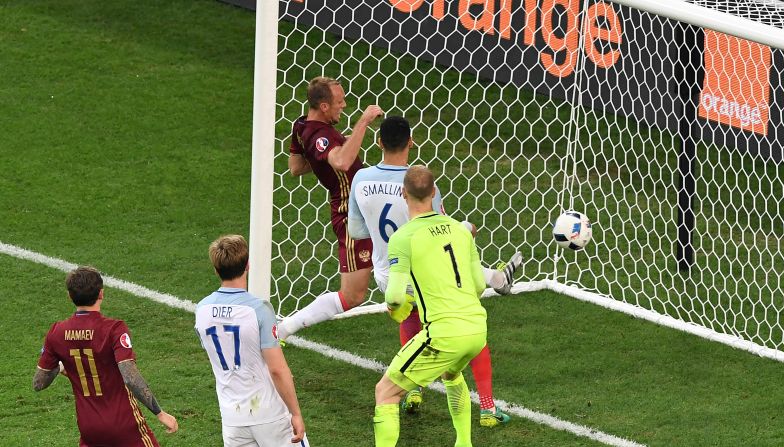 England's goalkeeper Joe Hart, center, looks at the ball going into his net as Russia scores at the end of the game.  Russia's <a href="index.php?page=&url=http%3A%2F%2Fwww.cnn.com%2F2016%2F06%2F11%2Ffootball%2Fengland-russia-euro-2016%2Findex.html">92nd minute equalizer</a> denied England victory.