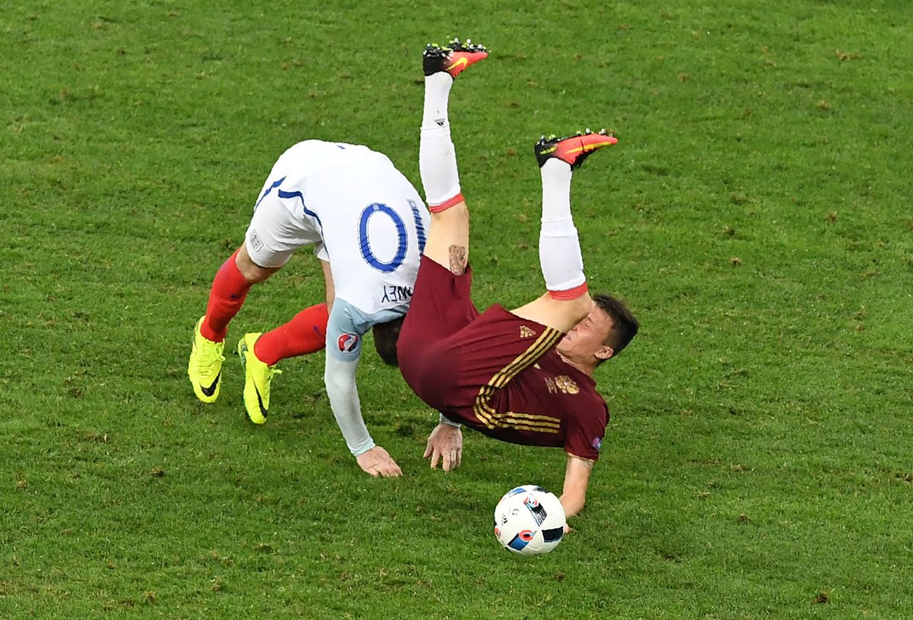 England forward Wayne Rooney, left, collides with Russia midfielder Aleksandr Golovin.