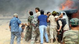 Forces loyal to Libya's UN-backed unity government attempt to evacuate a passenger stuck inside a vehicle after it caught on fire following a car-bomb attack nearby carried out by an Islamic State (IS) group jihadist at the western entrance of Sirte on June 2, 2016.
According to Libyan officials fighting resumed on June 1 on the outskirts of Sirte between their forces and jihadist during which three pro-government troops had been killed and 10 more wounded. Sirte was the hometown of slain dictator Moamer Kadhafi and, since seizing it in June last year, IS has turned it into a recruitment and training camp / AFP / MAHMUD TURKIA        (Photo credit should read MAHMUD TURKIA/AFP/Getty Images)