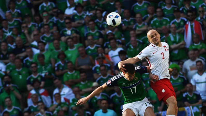 Northern Ireland's Paddy McNair, left, vies for the ball with Poland's Michal Pazdan. 